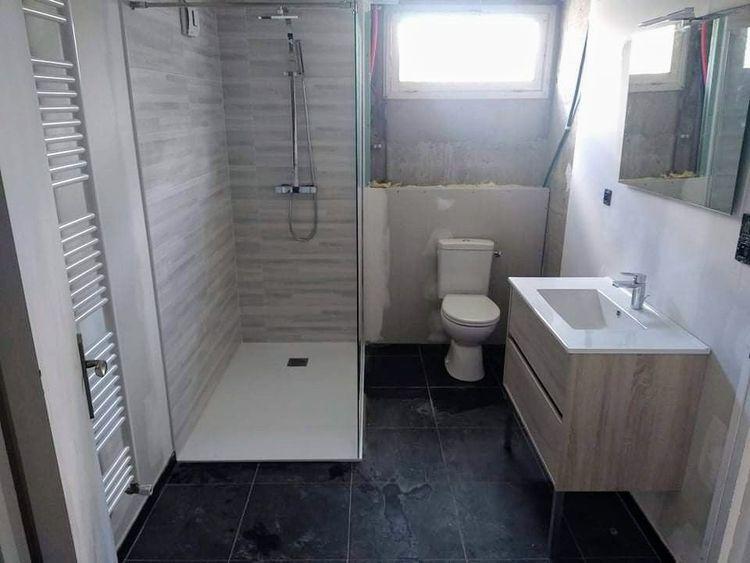 transformation d'une buanderie en salle d'eau avec wc, bac à douche blanc 120x90 avec paroi fixe meuble suspendu couleur bois et vasque blanche sèche serviette à eau sur chaudière gaz