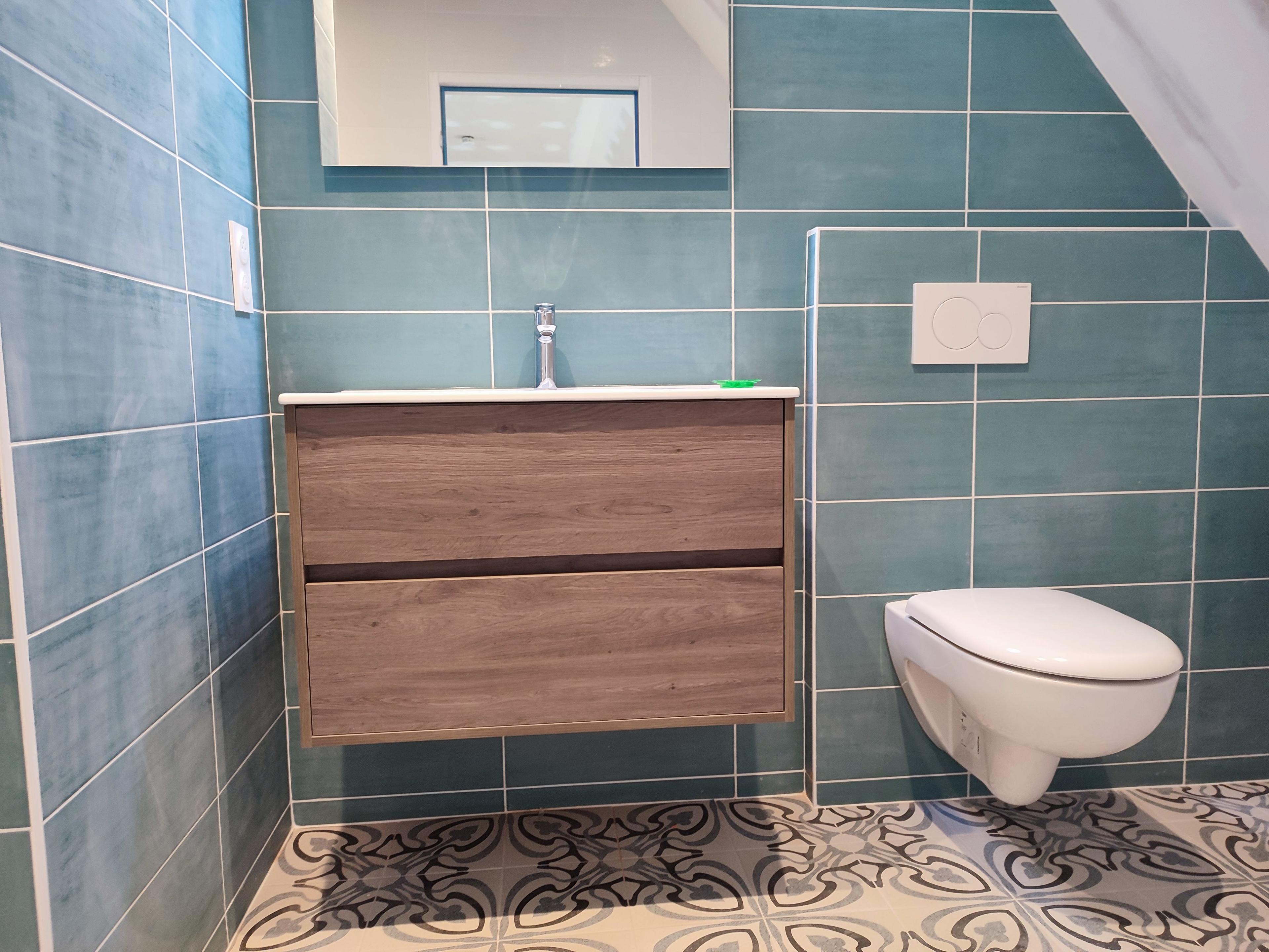 meuble de salle de bain de couleur bois avec wc suspendu et faïence bleue