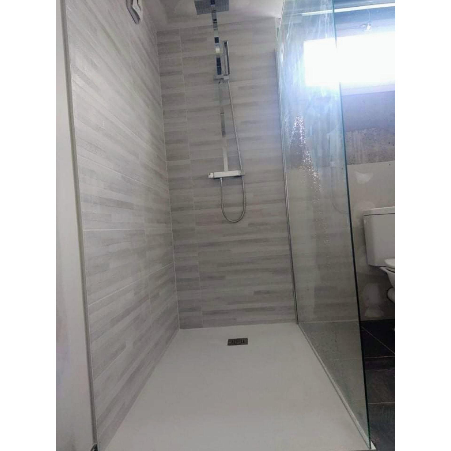 mise en faïence de l'espace douche, avec la pose de la colone de douche et des éléments sanitaires, paroi de douche fixe et bac à douche en dimension de 120x90