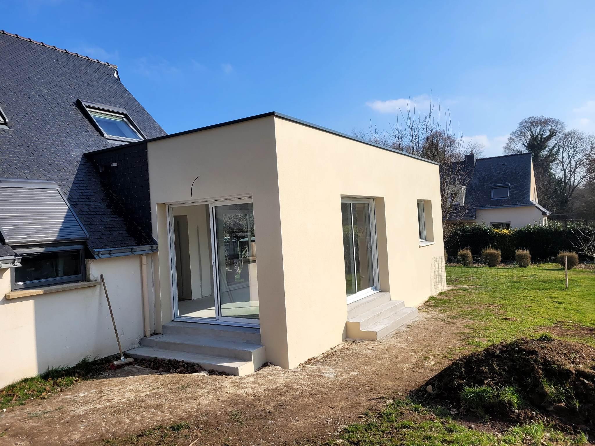 Vu de l'extension finie avec les marches en béton et les enduits beige.